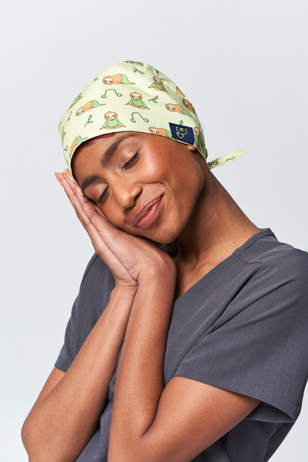 A Dentist Wearing a Dr. Woof Little Sloth Surgical Scrub Cap Tie Back